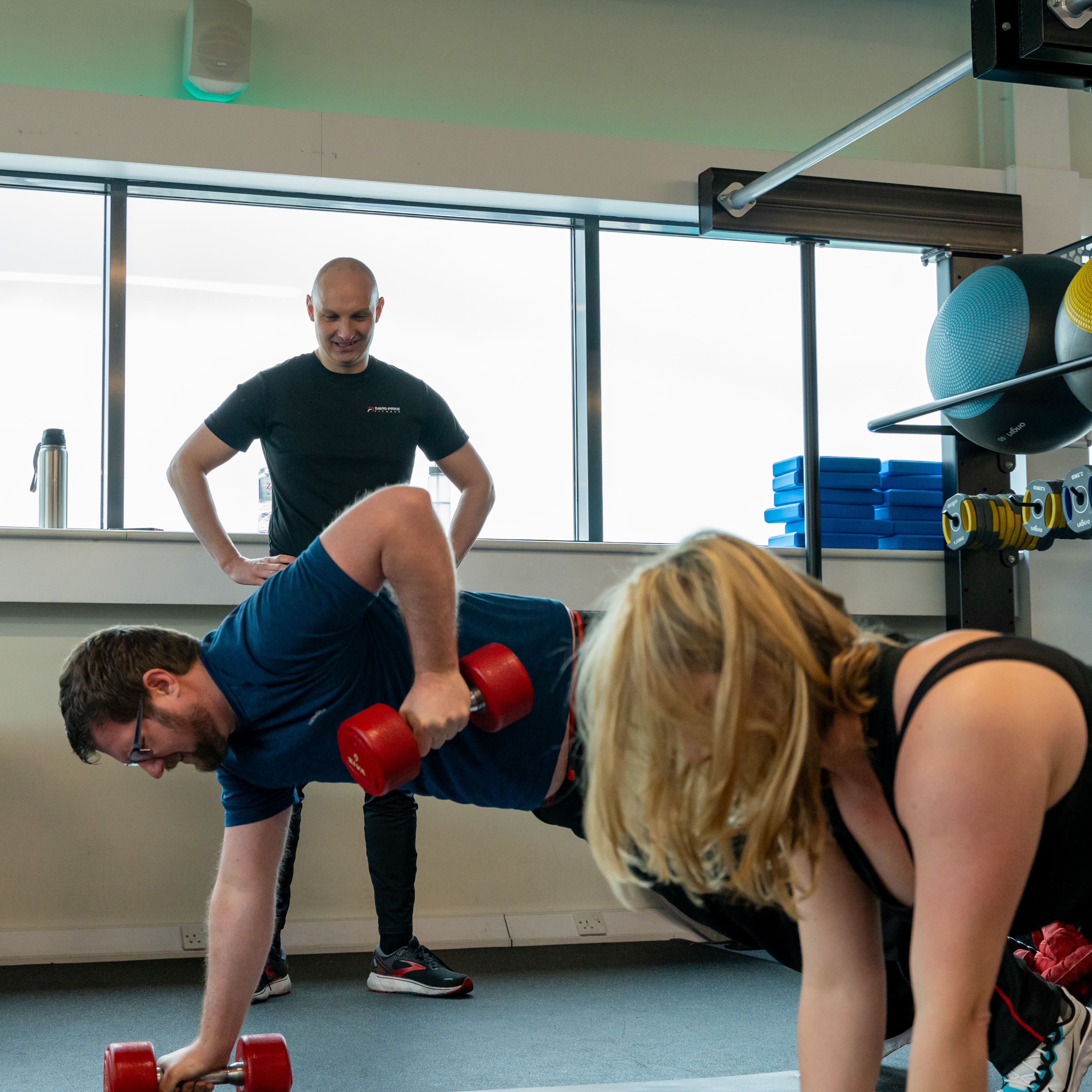 Personal trainer in Norwich coaching clients performing renegade rows during a gym session